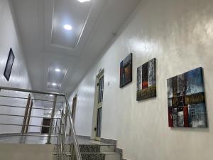 una escalera con cuatro pinturas en la pared en First Royal Beam Hotel, en Makurdu