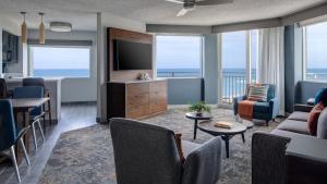 Sala de estar con sofá, TV y mesa en Marriott Hutchinson Island Beach Resort, Golf & Marina, en Stuart