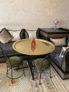 een tafel en stoelen in een woonkamer met een bank bij Appartement cosy Paris centre Montmartre in Parijs