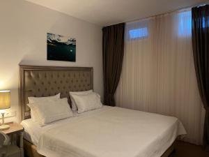 アラカティにあるBramasole Alaçatı Butik Hotelのベッドルーム1室(白いシーツ付きのベッド1台、窓付)
