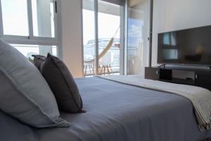 Un dormitorio con una cama grande y un televisor de pantalla plana. en Panoramico Hollywood Palermo, en Buenos Aires