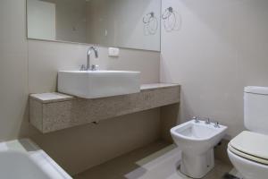 Un baño blanco con lavabo e inodoro. en Panoramico Hollywood Palermo, en Buenos Aires 47 fotos más