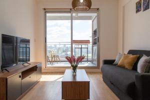Una sala de estar con un sofá y un televisor. en Panoramico Hollywood Palermo, en Buenos Aires