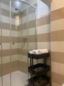 a bathroom with a shower with a towel on a stool at Pension Soutěsky in Hřensko
