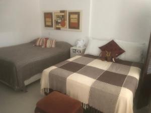 a bedroom with two beds and a teddy bear sitting on a bed at Studio Residencial Montevideo in Osório