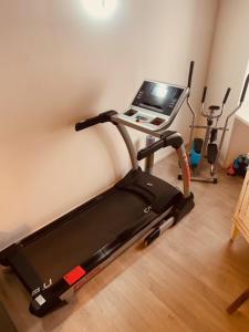 a treadmill in a room with a laptop on it at Contrada della Fontana Luxury Apartment in Levico Terme