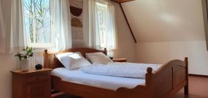 een slaapkamer met een bed met witte lakens en een raam bij Bungalowpark Bij de Bronnen in Nutter