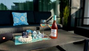 a table with two glasses and a bottle of wine at Kikötő Sétány Apartman III. in Balatonszemes