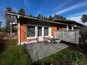 una casa con una terrazza con due sedie e un tavolo di Rauhallinen rivitalon pääty a Porvoo