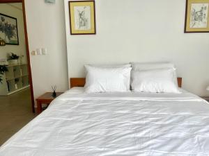 ダナンにあるLuxury Center Riverside Apartmentの白いベッド(白いシーツ、枕付)