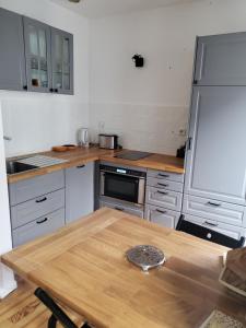 une cuisine avec une table en bois et un réfrigérateur dans l'établissement Studio cosy classé 3 étoiles dans cœur historique, à Arreau