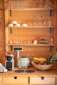 una cocina con estanterías de madera y un bol de fruta en Wooden House Apartments en Kaláthenai