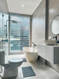 een badkamer met een bad, een toilet en een wastafel bij Villa Linns in Kerobokan