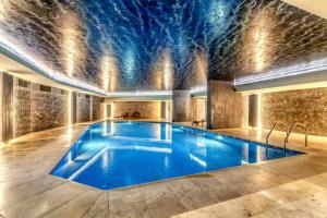 a large swimming pool in a building with a ceiling at Benesta Residence by NewInn in Istanbul