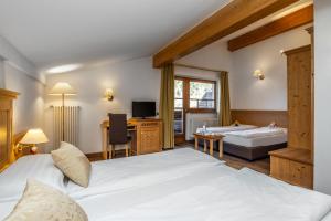 um quarto de hotel com duas camas e uma banheira em Family Hotel Adriana em Ledro