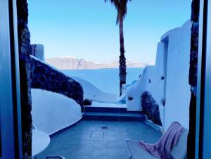 a view of the ocean from a room with a window at HIDEAWAY CAVE HOUSE in Oia +1 photo