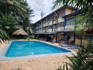 a hotel with a swimming pool in front of a building at Foyer du Marin in Douala