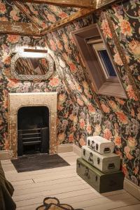 a room with a fireplace with floral wallpaper at Daylily Cottage - Two Bedroom Georgian Cottage in Central Bath in Bath