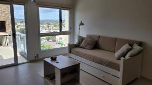 a living room with a couch and a coffee table at Departamento moderno con cochera y parrilla, amplio y luminoso in Puerto Madryn
