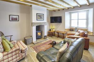 a living room with leather furniture and a fireplace at Cumbria, en-suite bathrooms, North Pennines in Alston