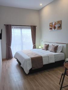 Un dormitorio con una cama grande y una ventana en 44 Guest House Syariah en Purwokerto