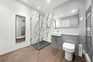 a bathroom with a toilet and a shower and a sink at South Kensington Luxury Suite in London
