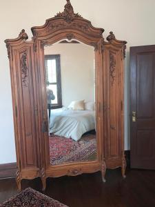 espejo de madera grande en una habitación con cama en Historic Queen Anne Mansion, en Quincy