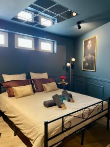 a bedroom with a large bed with blue walls and windows at Sleep'In Cities Le Saphir Balnéo in Albi