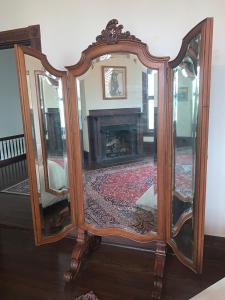 a large mirror sitting in a room with a fireplace at Historic Queen Anne Mansion in Quincy