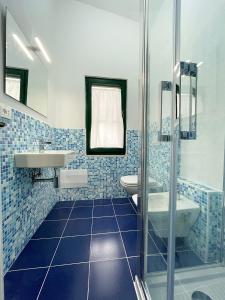een blauw betegelde badkamer met een wastafel en een toilet bij Mare blu in Orosei