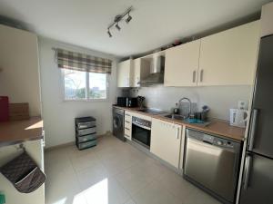 a small kitchen with white cabinets and appliances at Pedro’s Apartment in Sucina