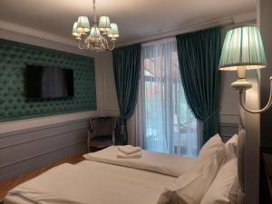 Habitación de hotel con cama y lámpara de araña. en Casa Timpuri Vechi, en Sibiu