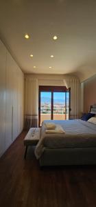 a bedroom with a large bed and a large window at 2SE Apartment in Korçë
