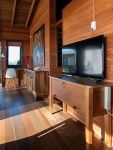 a living room with a large flat screen tv at Casa dos Imbês - Frente ao Mar in Barra de Ibiraquera
