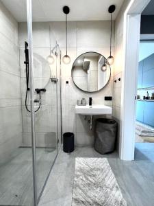 a bathroom with a shower and a sink and a mirror at Stylische Wohnung mit Balkon in Graz