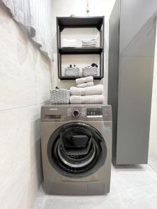 a washer and dryer in a bathroom with towels at Stylische Wohnung mit Balkon in Graz