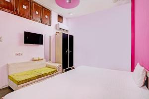 una camera con un grande letto e un divano di OYO Hotel Rose Valley a Indore