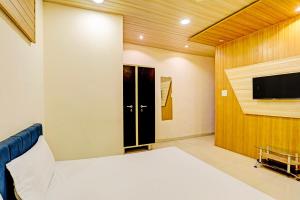 una camera con letto e TV a schermo piatto di OYO Hotel Rose Valley a Indore