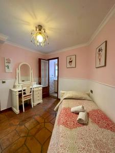 een slaapkamer met een bed, een bureau en een spiegel bij Nerja's center Apartment in Nerja