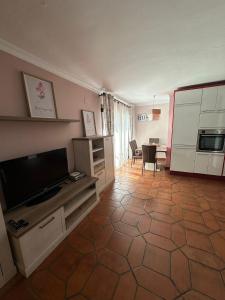 een woonkamer met een flatscreen-tv en een keuken bij Nerja's center Apartment in Nerja