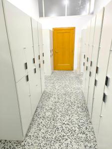 a hallway with white lockers and a yellow door at CAPSULE INN VALENCIA Hostel in Valencia