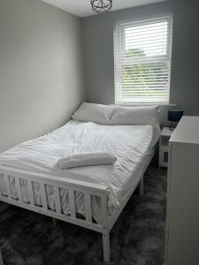 a white bed in a room with a window at Thornaby Apartment in Thornaby on Tees