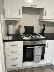 a kitchen with a stove and white cabinets at Thornaby Apartment in Thornaby on Tees