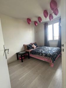 - une chambre avec des coeurs en papier rose accrochés au mur dans l'établissement sweet room, à Garges-lès-Gonesse