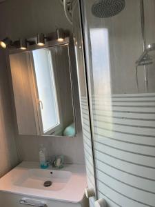 La salle de bains est pourvue d'un lavabo, d'un miroir et d'une douche. dans l'établissement sweet room, à Garges-lès-Gonesse
