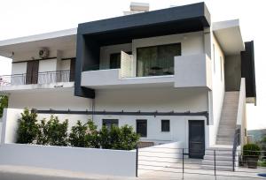 a white house with a black facade at Gaia Apartment II in Parga