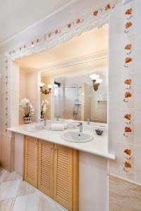 łazienka z 2 umywalkami i dużym lustrem w obiekcie Mikaela's Pool House w mieście Afandu