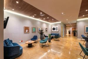 a waiting room with blue couches and chairs at Hotel Holiday Inn Express & Suites Medellin, an IHG Hotel in Medellín