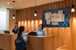 a group of people standing at a reception desk at Hotel Holiday Inn Express & Suites Medellin, an IHG Hotel in Medellín