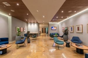 - une salle d'attente avec des tables et des chaises bleues dans l'établissement Hotel Holiday Inn Express & Suites Medellin, an IHG Hotel, à Medellín
